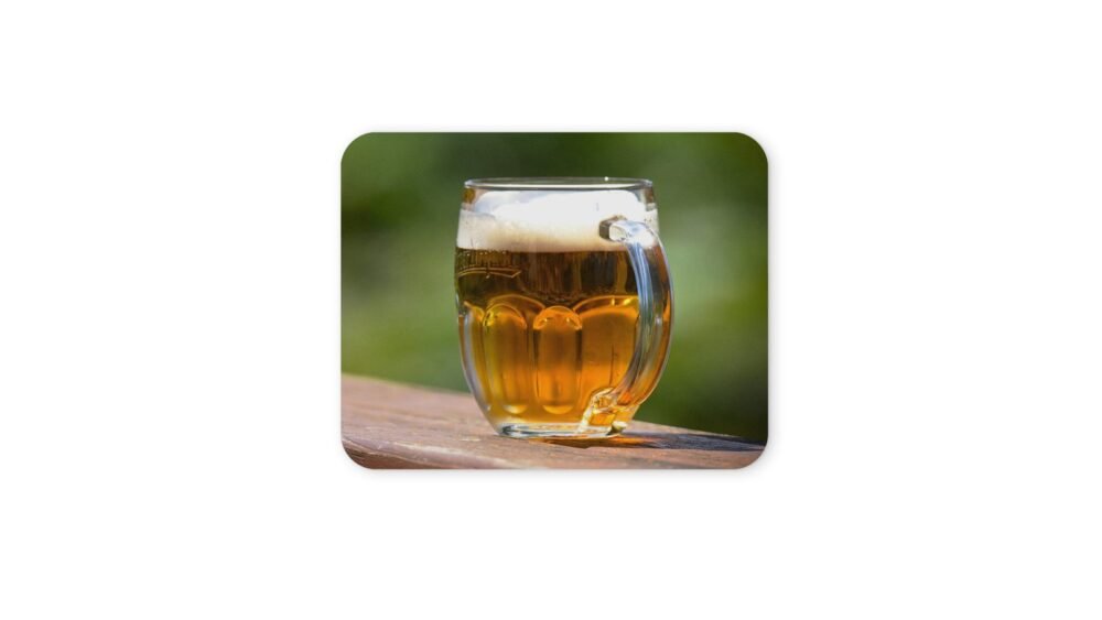 Söröpohár fa asztalon, zöld háttérrel.