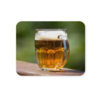 Söröpohár fa asztalon, zöld háttérrel.