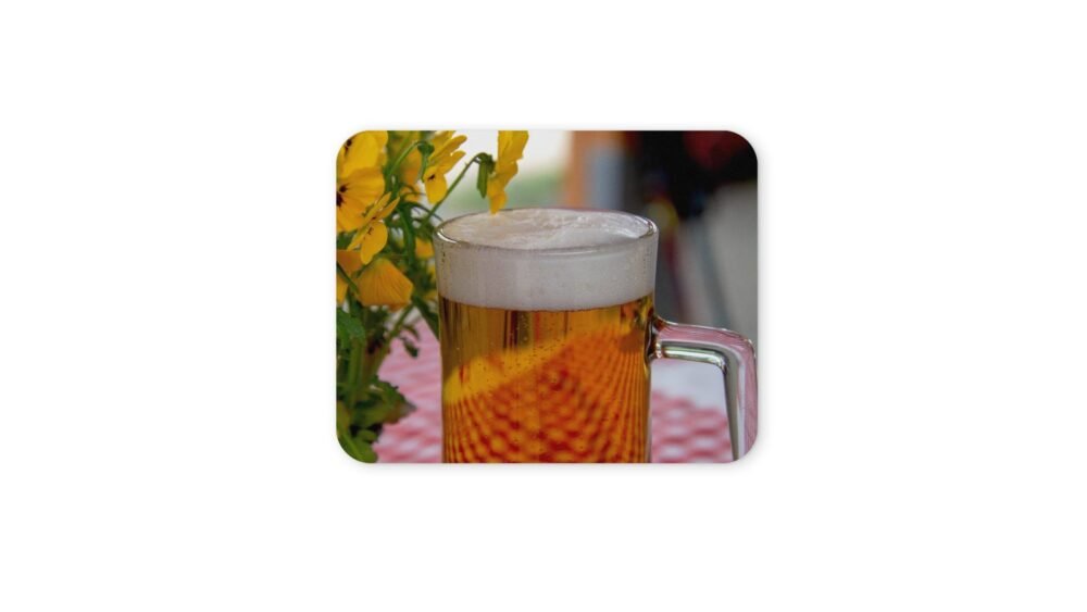 Sörö egy egérpadon, virágok mellett.