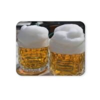 Két pohár sör sűrű habbal, egy egérpadon.