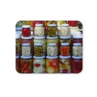 Többféle savanyúság üvegekben, színes paprikák, fokhagyma, uborka.