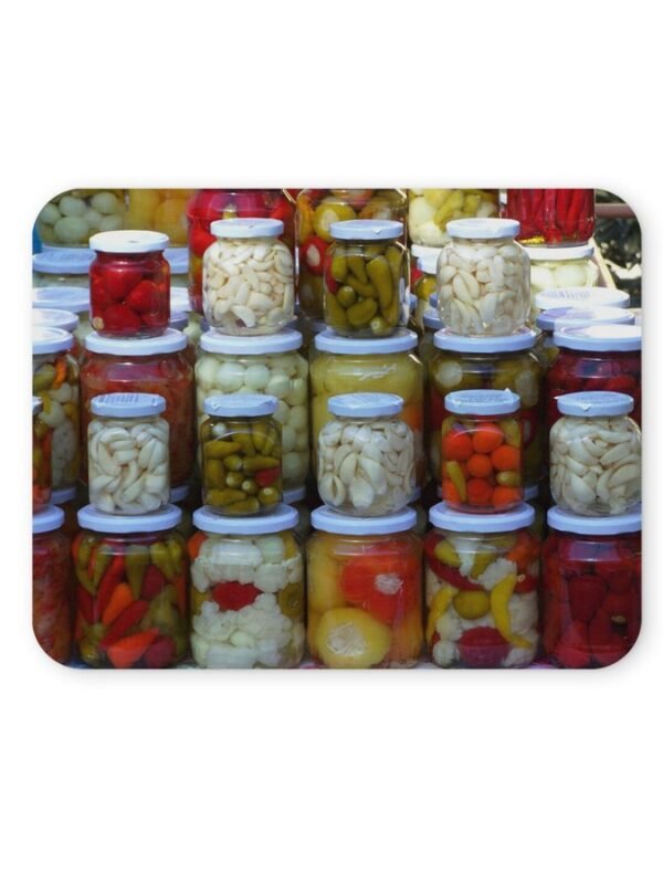 Többféle savanyúság üvegekben, színes paprikák, fokhagyma, uborka.